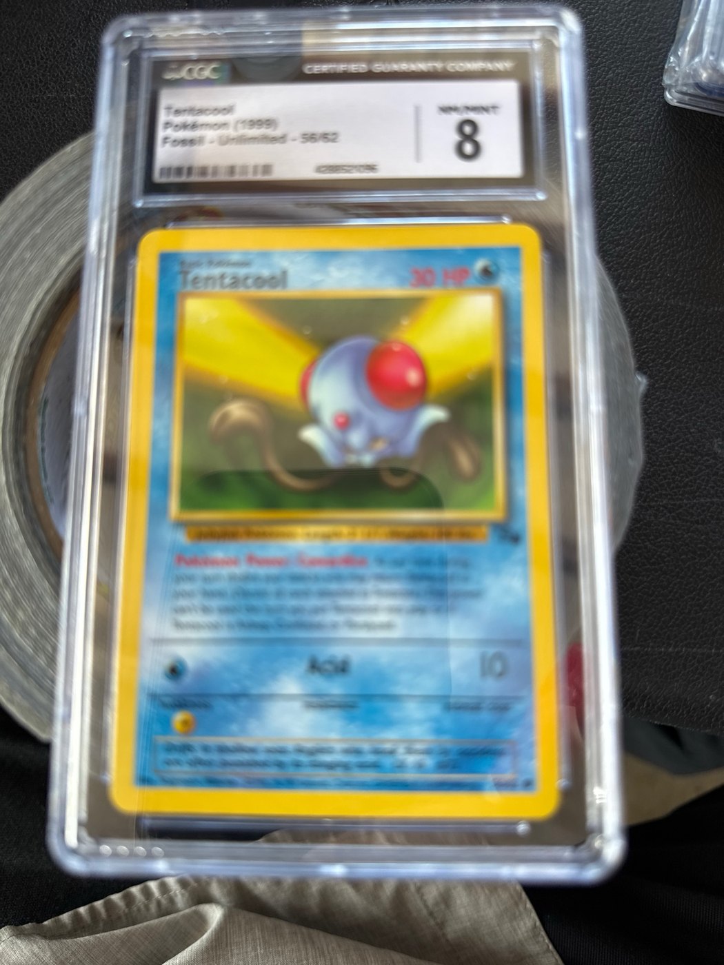 Tentacool Fossil Unlimited Pokémon card graded CGC 8, original photo