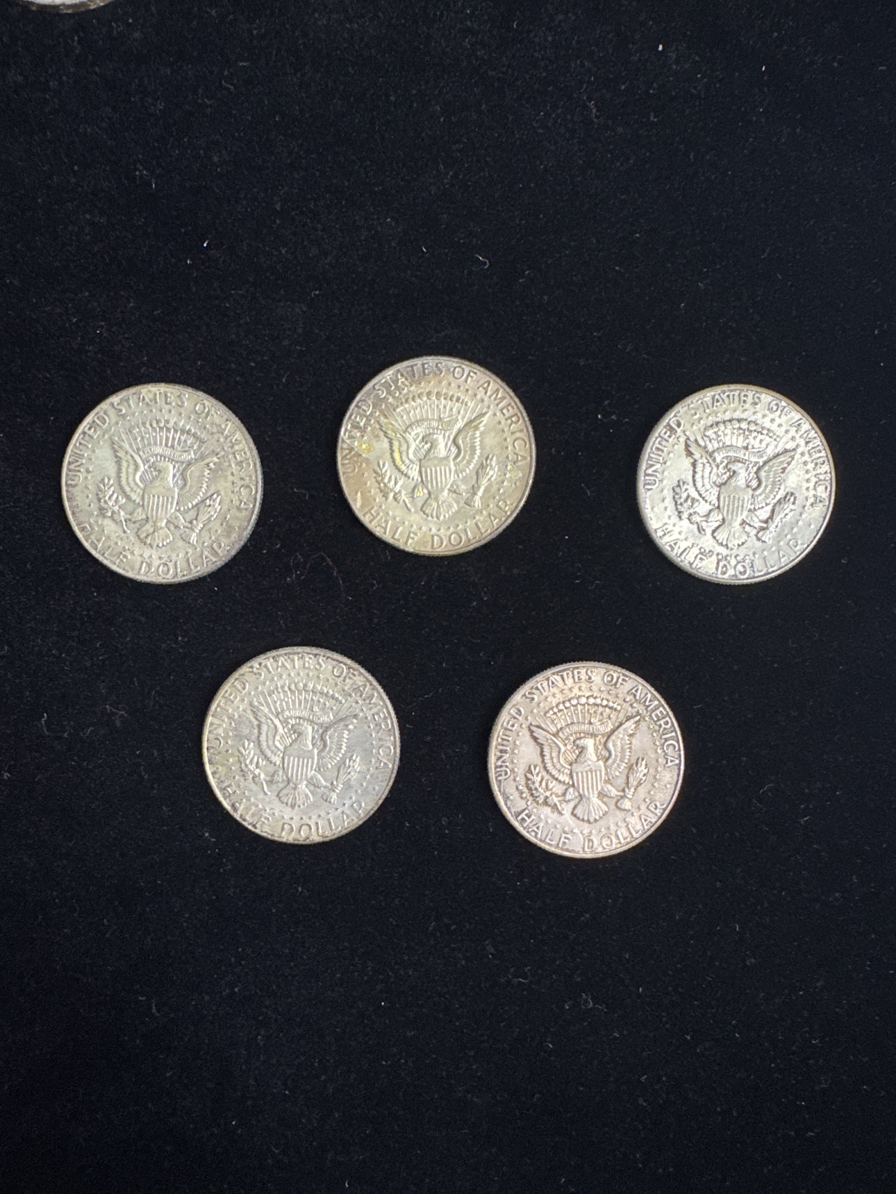 Reverse view of the five circulated Kennedy half dollars
